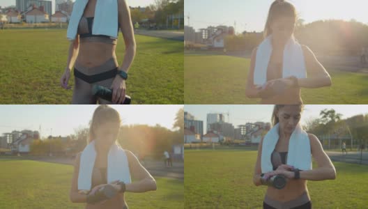 迷人的女人在城市体育场跑步时用智能手表检查她跑了多少。高清在线视频素材下载