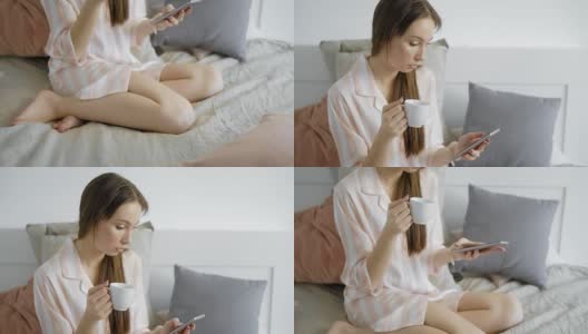 在假期的早上，当一个黑发女孩醒来的时候，她在床上喝着咖啡，在她的智能手机上打字高清在线视频素材下载