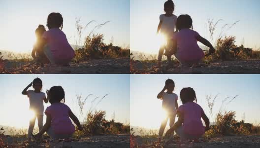 亚洲女孩玩干树枝与姐姐在日落高清在线视频素材下载