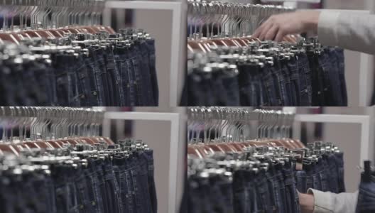中年男子在商店里挑选牛仔裤高清在线视频素材下载