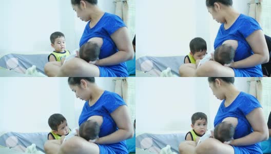 单身母亲照顾她的儿子，一个婴儿母乳喂养高清在线视频素材下载