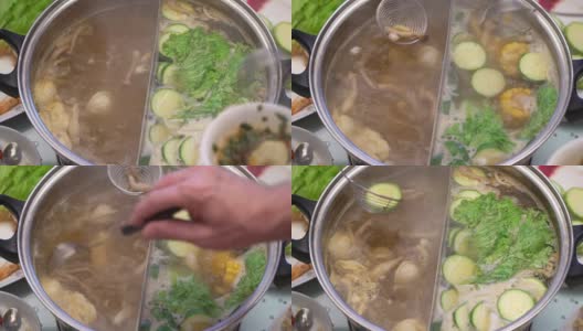 概念火锅家庭烹饪。从沸腾的汤中取出玉米、蘑菇和饺子高清在线视频素材下载