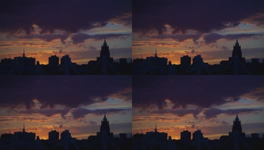 美丽的日落到夜晚过渡到城市中心的天际线。夜晚城市天际线日落。与耀斑轮廓。间隔拍摄。鸟儿在夕阳中飞翔高清在线视频素材下载