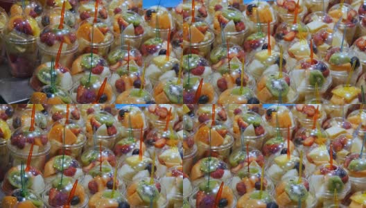 2017年9月22日-西班牙巴塞罗那，Mercator de la Boqueria食品市场:一个巨大的柜台，里面有热带水果，芒果，百香果，猕猴桃，塑料包装的香蕉高清在线视频素材下载