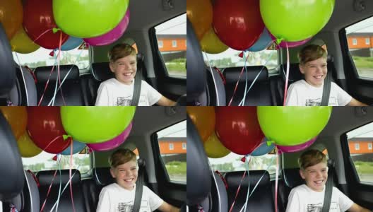快乐的孩子在车里。喜庆心情，笑一笑，欢声笑语。汽车里的气球高清在线视频素材下载