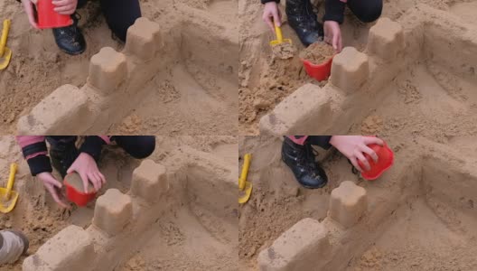 小女孩在院子里玩沙子。建造一座沙堡高清在线视频素材下载