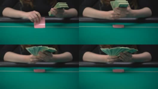 看牌的女人把钱放在赌桌上，浪费钱高清在线视频素材下载