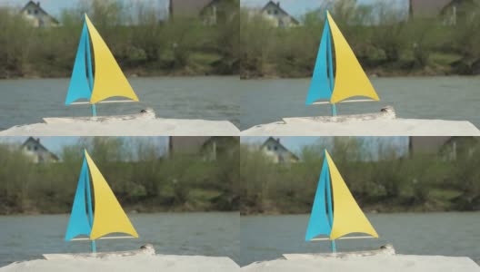 沙滩上是自制的玩具帆船，背景是现在的山河高清在线视频素材下载
