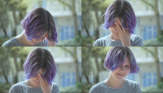 一个紫色头发戴着牙套的少女摇着头高清在线视频素材下载