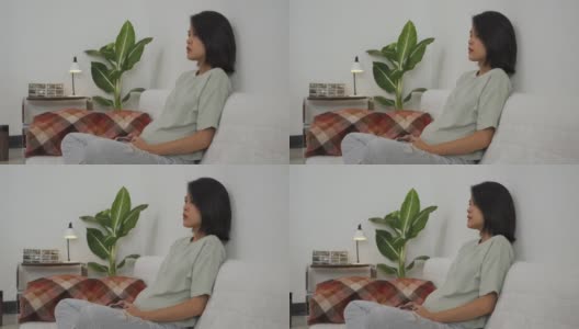 一位亚洲年轻女子在客厅用摇杆玩电子游戏高清在线视频素材下载