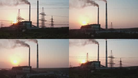 在日落有害电站的全景。大型工厂旁边耸立着高大的电塔，夜空中耸立着烟囱。照相机上升。高清在线视频素材下载