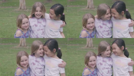 快乐的多民族混血小女孩在公园里拥抱和欢笑，积极的健康理念高清在线视频素材下载