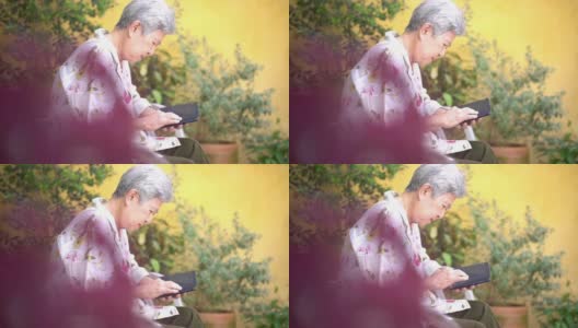 亚洲老人老年人老年人妇女老年人男性使用手机智能手机户外。成熟的退休生活高清在线视频素材下载
