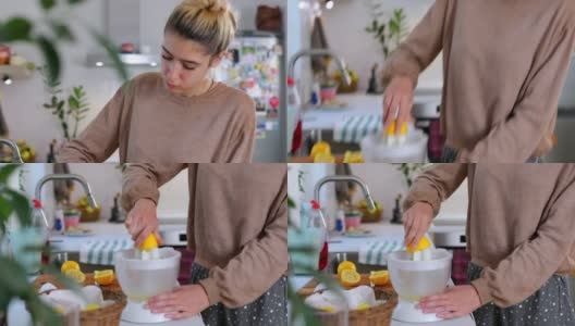 年轻漂亮的女人正在做新鲜的柠檬水高清在线视频素材下载