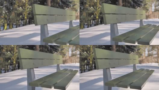 一个阳光明媚的日子，公园里绿色长凳的特写镜头。高清在线视频素材下载