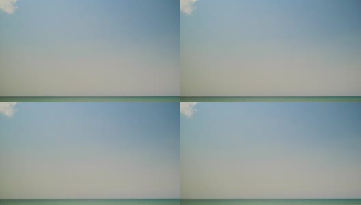 蓝色的海洋和天空的背景，夏天的概念。正午蔚蓝天空的背景，缓缓飘浮的云朵。模糊的自然，假日或周末横幅的想法，实时视频素材高清在线视频素材下载