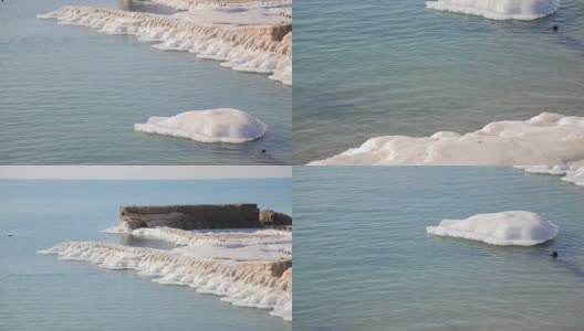 海岸边的石墩上，覆盖着白雪高清在线视频素材下载