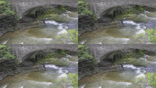 陶诺克瀑布在石桥下流淌高清在线视频素材下载