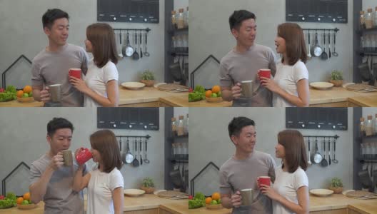 美丽幸福的亚洲夫妇一起在厨房喝咖啡。男人和女人一边吃早餐一边聊天。年轻的亚洲夫妇在家享受浪漫时光。高清在线视频素材下载