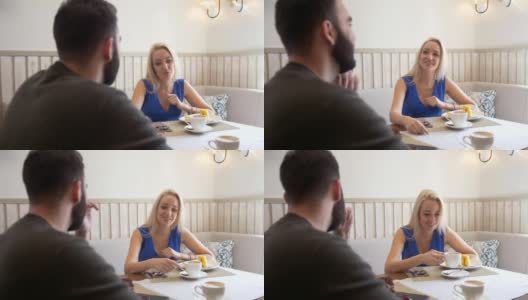 幸福的白种情侣在咖啡馆里喝着咖啡吃着甜点约会高清在线视频素材下载