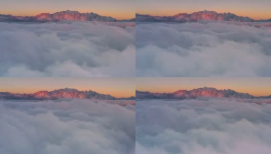 日出时，云海在雪山前翻滚，显得格外壮观高清在线视频素材下载