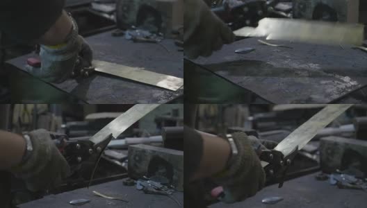 女铁匠在她的车间里用钢丝切割机切割一块铝高清在线视频素材下载