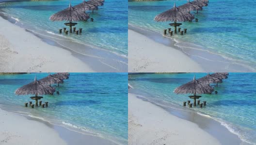 马尔代夫海滩的海洋酒吧。绿松石蓝色的大海里的热带小屋座位用慢镜头拍摄高清在线视频素材下载