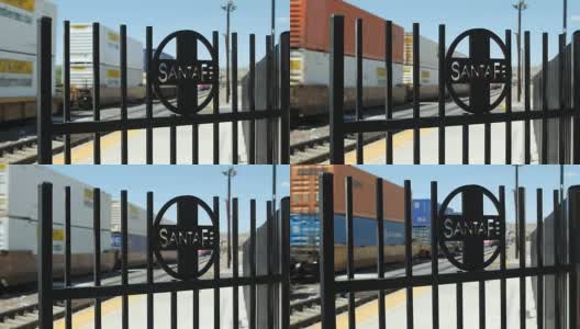 A freight train passes a Santa Fe iron gate in a rail yard  on a railroad in Arizona高清在线视频素材下载
