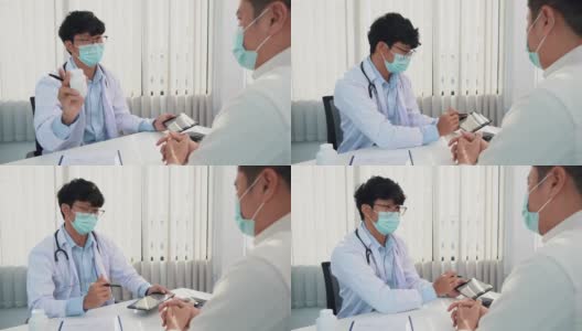 医生正在解释在病毒爆发期间戴着口罩用药片治疗病人的方法。高清在线视频素材下载