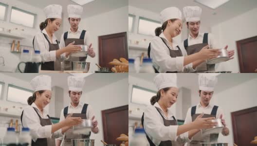 两个年轻的亚洲人在厨房一起做饭高清在线视频素材下载