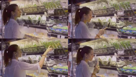 快乐的年轻妇女家庭主妇站在杂货店买绿色蔬菜高清在线视频素材下载