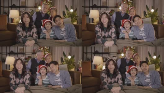 亚洲家庭在圣诞节晚上坐在一起看电视。家庭，世代，圣诞节和人的概念高清在线视频素材下载