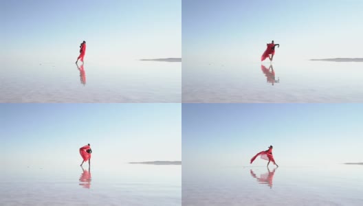 美丽的芭蕾舞演员在湖上用红色薄纱跳舞高清在线视频素材下载