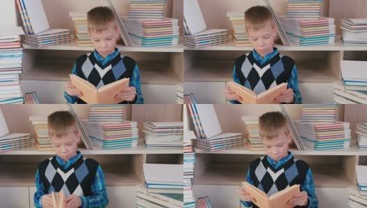 七岁的小男孩坐在书堆里专心地看书。高清在线视频素材下载
