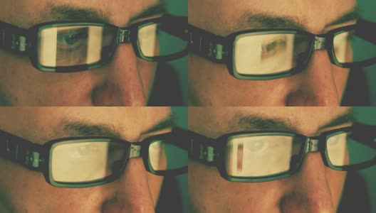 极端近距离的男人脸，眼睛，眼镜。从时尚眼镜上的笔记本电脑屏幕反射。高加索白人。男人肖像。浏览互联网的概念。Sinematic电影看。高清在线视频素材下载