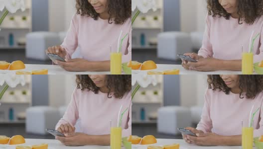 微笑的混血女孩在智能手机上滚动，使用减肥应用程序，健康高清在线视频素材下载