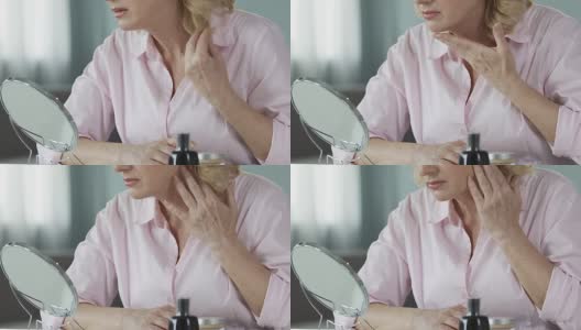 不满意的女人在她的50多岁看手镜，抗衰老的化妆品高清在线视频素材下载