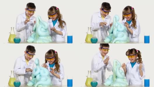 两个可爱的化学家孩子做有趣和成功的实验与蓝色泡沫，玩，孤立在白色背景，慢动作高清在线视频素材下载