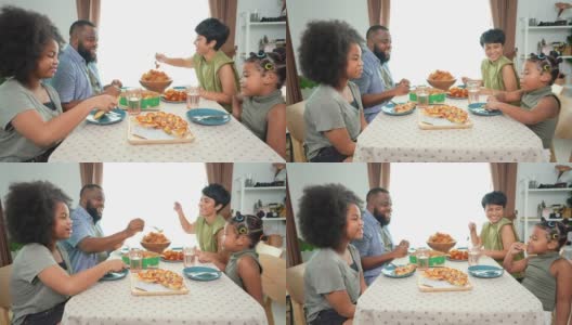 4K非洲混血家庭在家里一起吃炸鸡和披萨当晚餐高清在线视频素材下载