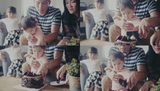 亚洲父亲抱着女儿切生日蛋糕(慢镜头)高清在线视频素材下载