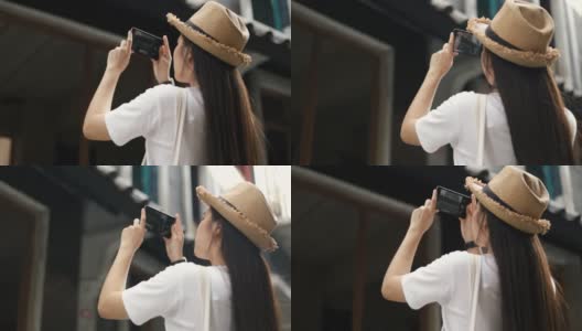 年轻美丽的亚洲旅行者戴着复古的帽子，用智能手机拍摄建筑照片。高清在线视频素材下载