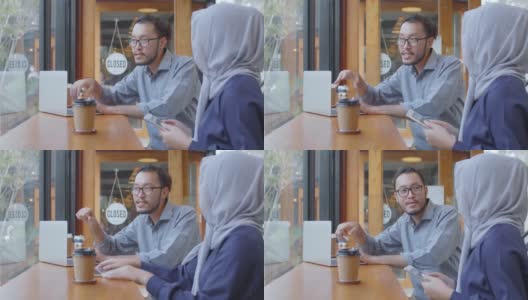 快乐多元的亚洲穆斯林年轻女子与朋友在咖啡馆会议上谈笑风生，多元文化开朗的人们围坐在café桌边喝咖啡高清在线视频素材下载
