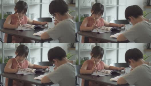 亚洲华人兄弟姐妹在家里练习书法高清在线视频素材下载