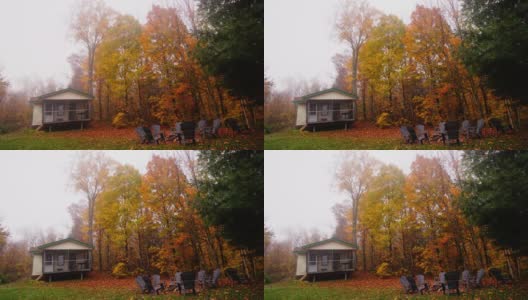 时光流逝:秋天，明亮的橙色树叶悬挂在一座老式房屋的屋顶前。高清在线视频素材下载