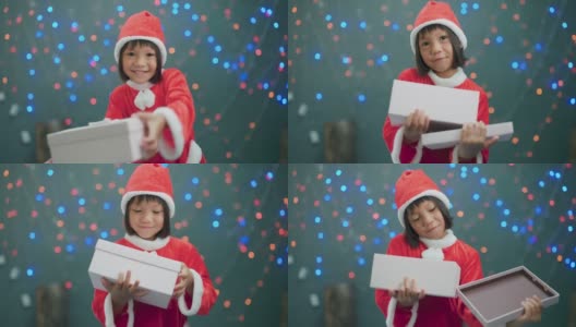 女孩穿着圣诞老人的衣服打开礼品盒。高清在线视频素材下载
