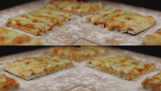 平面包披萨由奶酪在砧板上与面粉在黑色的背景下慢慢旋转高清在线视频素材下载