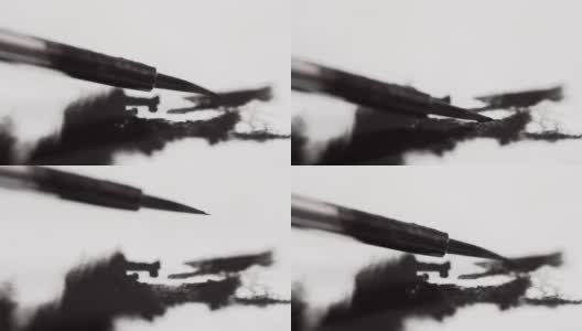 微距拍摄的画笔与黑色油漆在白纸上高清在线视频素材下载
