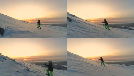 航拍:在金色的日出中，穿着雪鞋的运动女性走向雪山高清在线视频素材下载