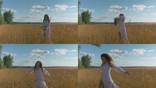 一个穿白衣服的女孩抛起野花，沿着麦田跑。高清在线视频素材下载
