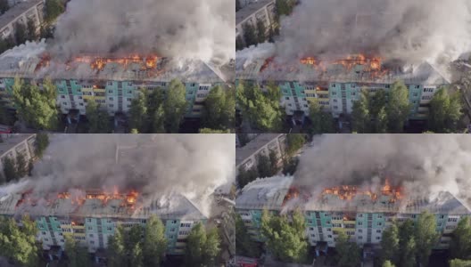 一所住宅的屋顶着火了。消防队员正在扑灭高层住宅楼屋顶上的一场火灾。高清在线视频素材下载